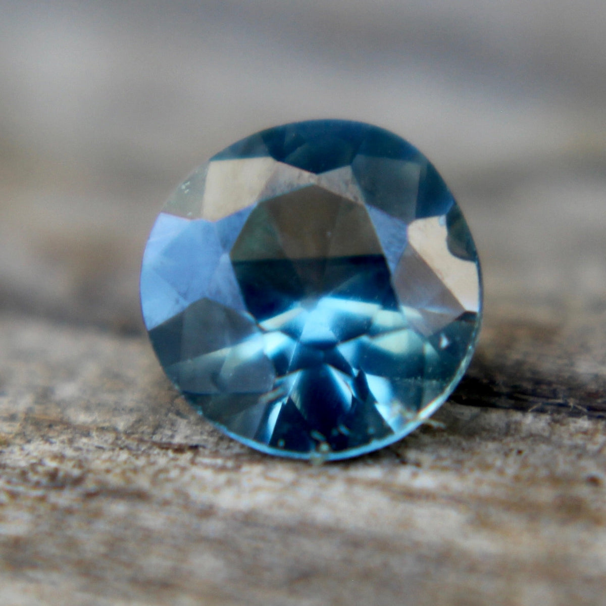 Side profile of the 0.59 carat round teal sapphire