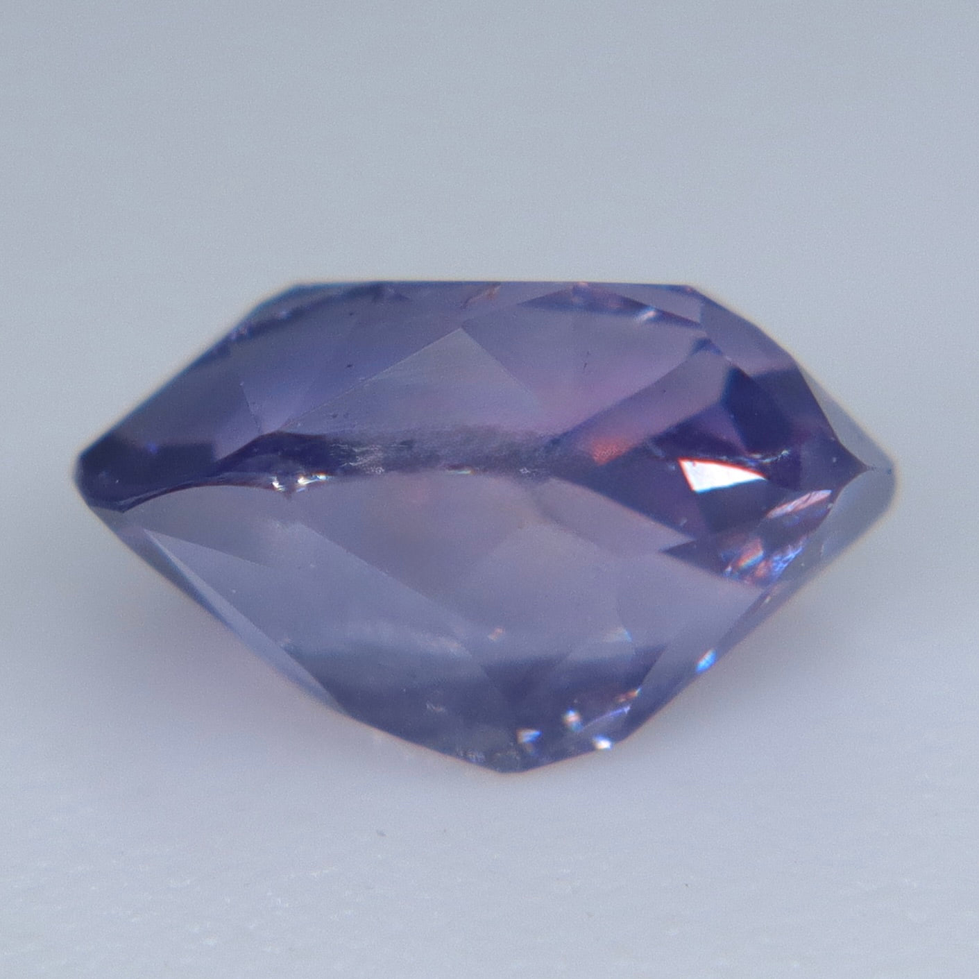 Alternate face-up view of the pinkish purple oval-cushion sapphire showing soft pink reflections