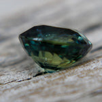 Angled view of a 1.28 carat faceted green sapphire loose gemstone