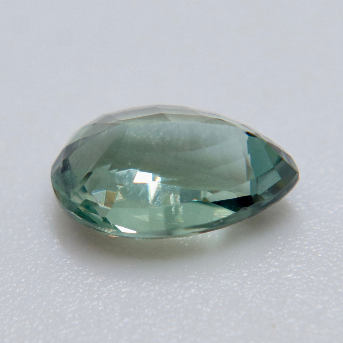 The same 1.54 ct Ceylon alexandrite photographed under two light sources for color comparison.