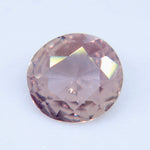 Close-up of a pale peach-pink Ceylon sapphire showing its table and surrounding facets