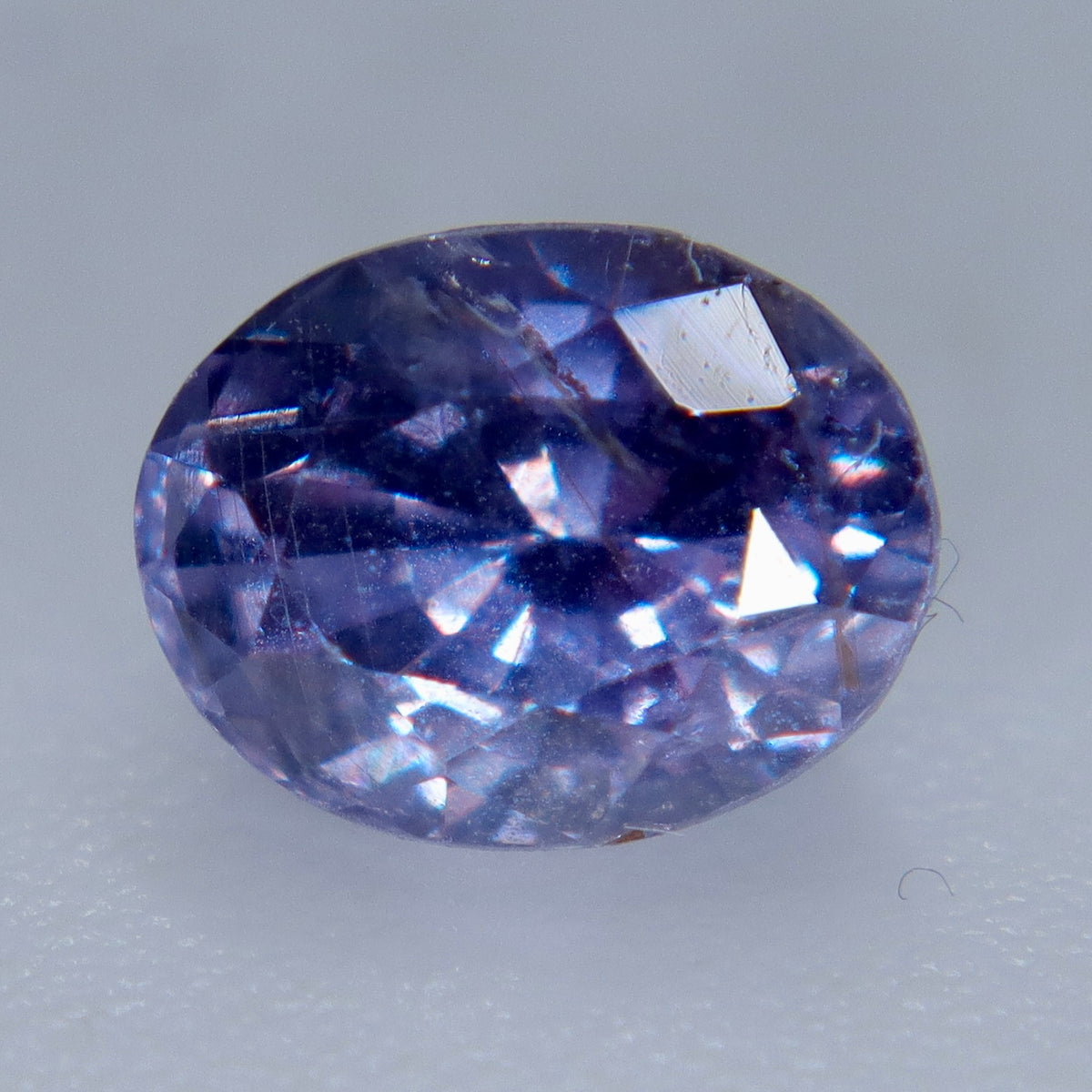 Close-up of an included oval purple sapphire showing its table and surrounding facets
