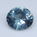 Close-up of an oval blue-teal sapphire showing its central table and surrounding facets