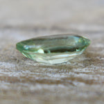 Close-up of the table and surrounding facets of a green pear sapphire.