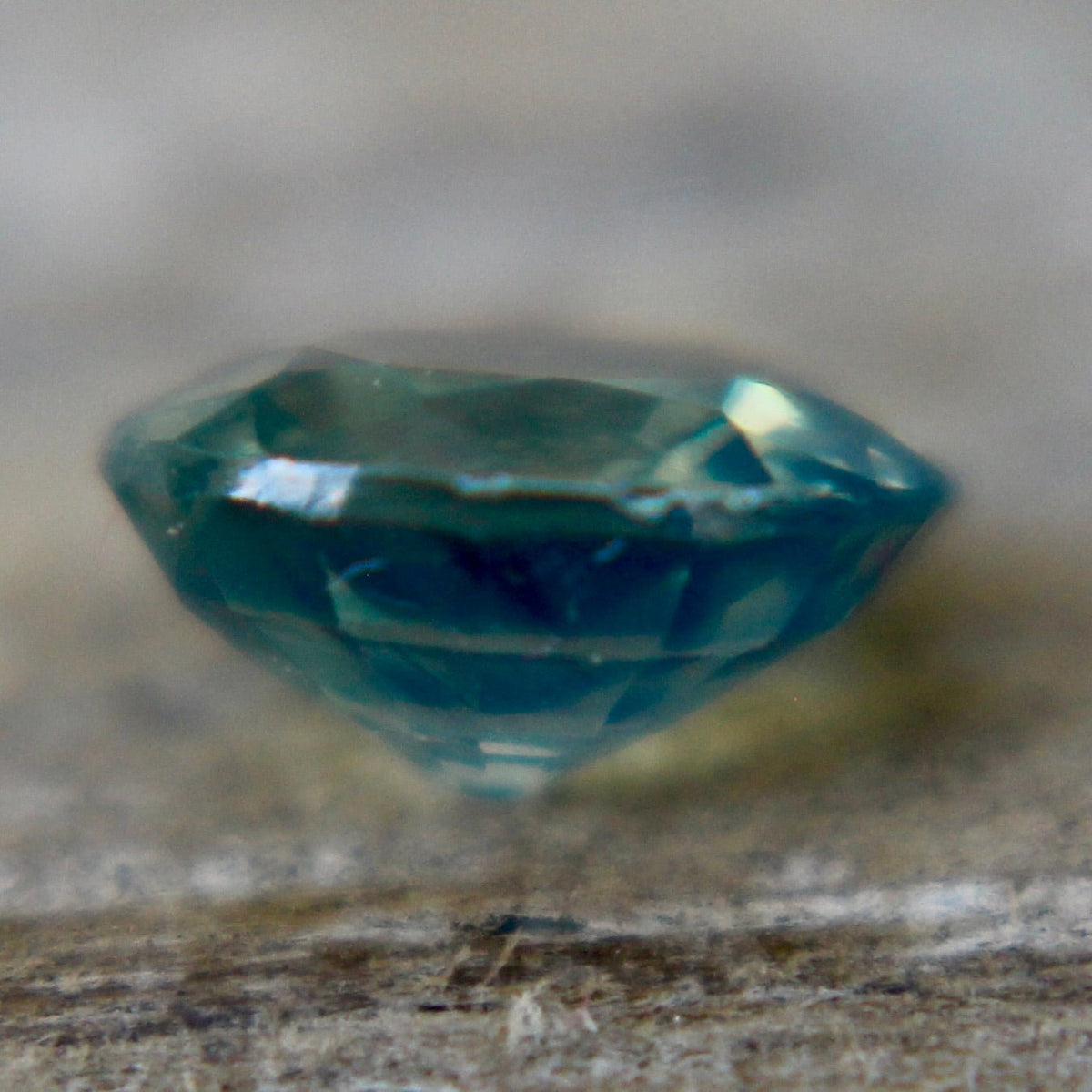 Close-up of the table and surrounding facets of a green sapphire.