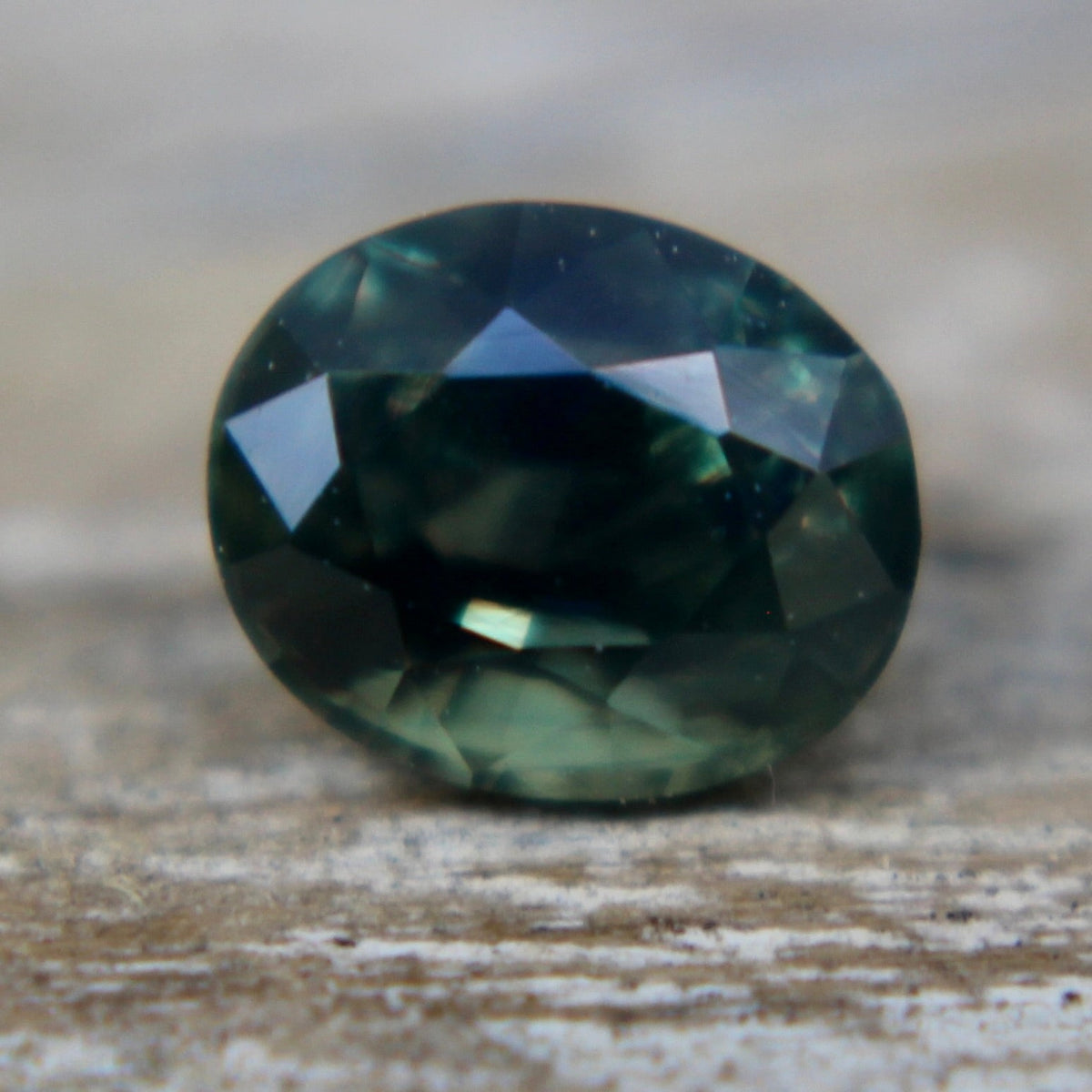 Close-up of the table and surrounding facets of a green sapphire.