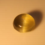 Face-up close-up of the 0.67 ct cat’s-eye gemstone on a light background