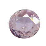 Face-up view of a 0.41 ct peach-pink sapphire with a roundish oval outline and visible inclusions