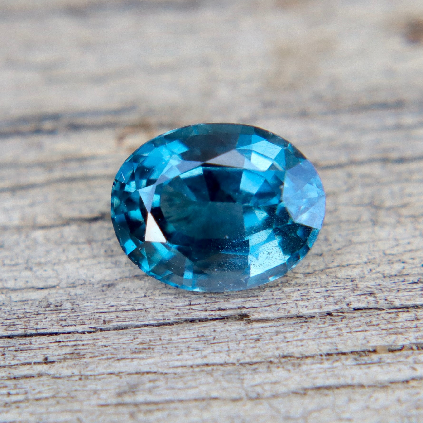Blue gemstone on a wooden surface