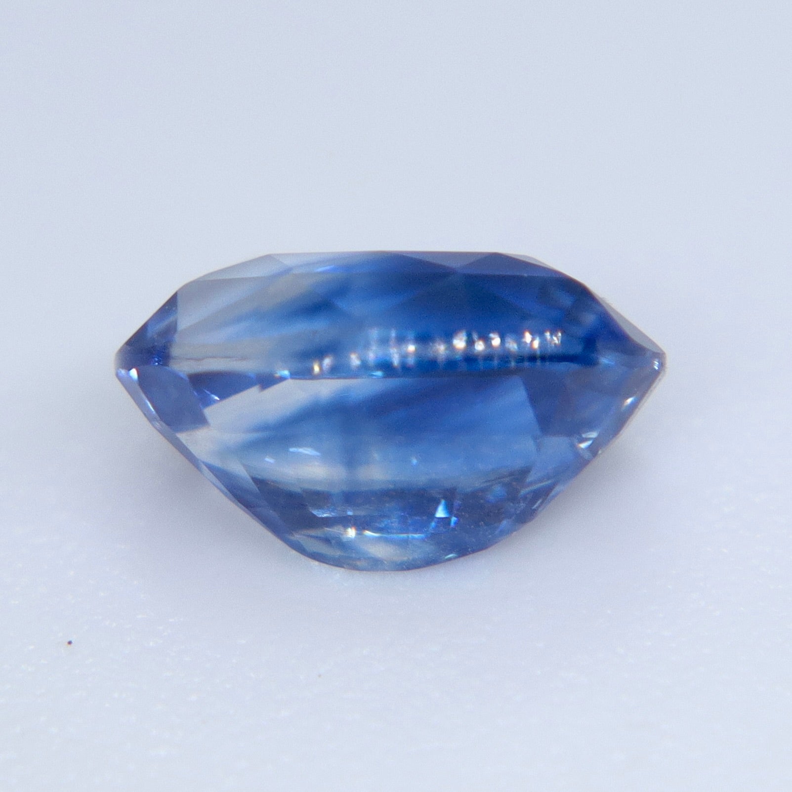 Close-up of natural blue sapphire showing cut and polished gemstone facets and bright sparkle