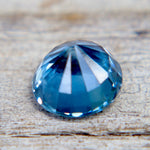 Natural teal sapphire stone close-up showing sparkle and VS clarity, earth sourced loose gemstone