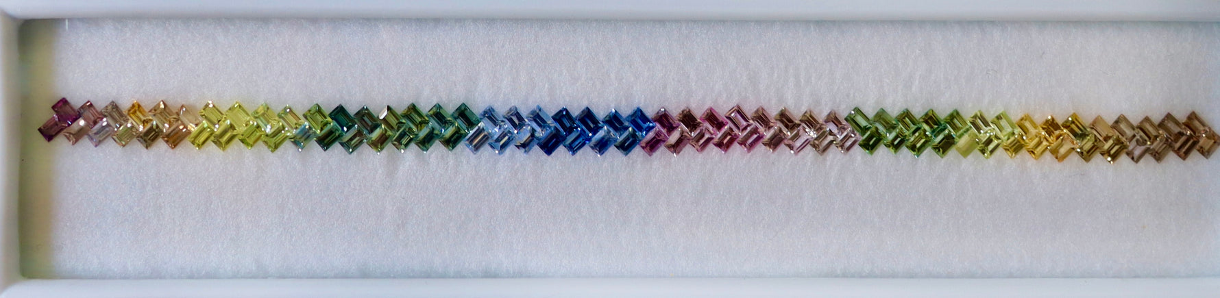 Loose sapphire set showing blue green sapphires, green sapphires, and golden tones, precision matched