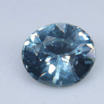 Natural Madagascar teal sapphire in an oval cut, viewed face-up on a light background