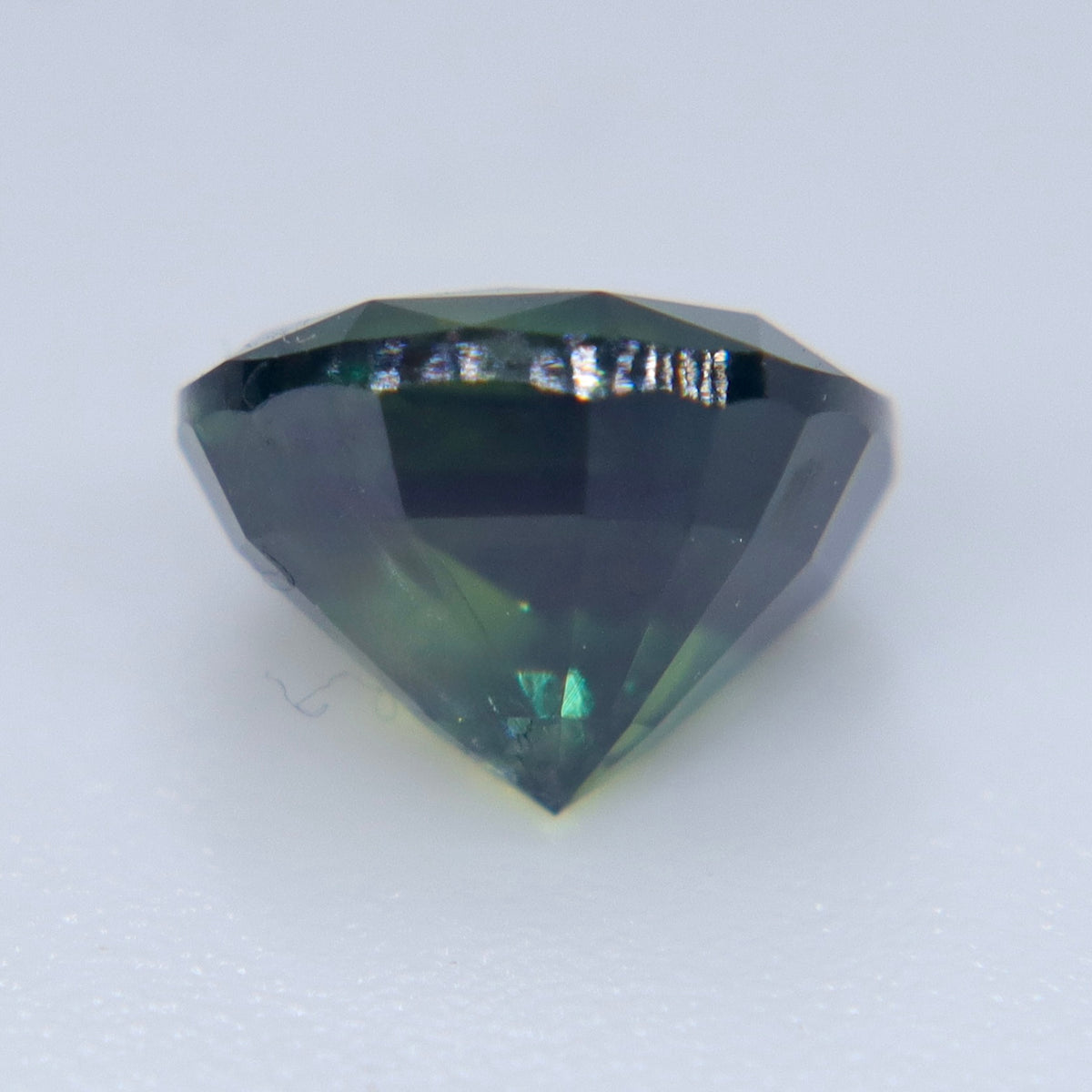 Rectangular cushion cut Australian green sapphire showing faceted crown