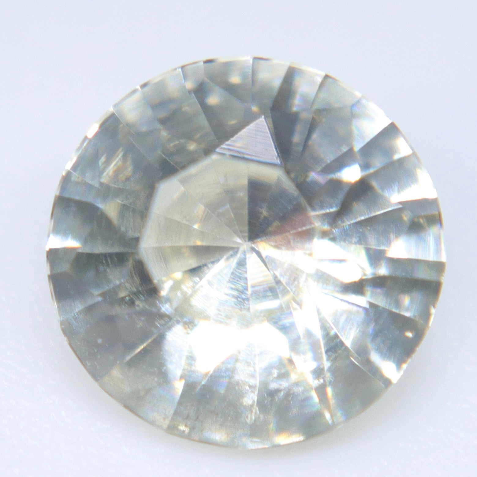 Round natural white sapphire viewed under light for a bespoke ring or pendant