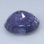 Side profile of a purple sapphire showing its crown, girdle, and deep pavilion