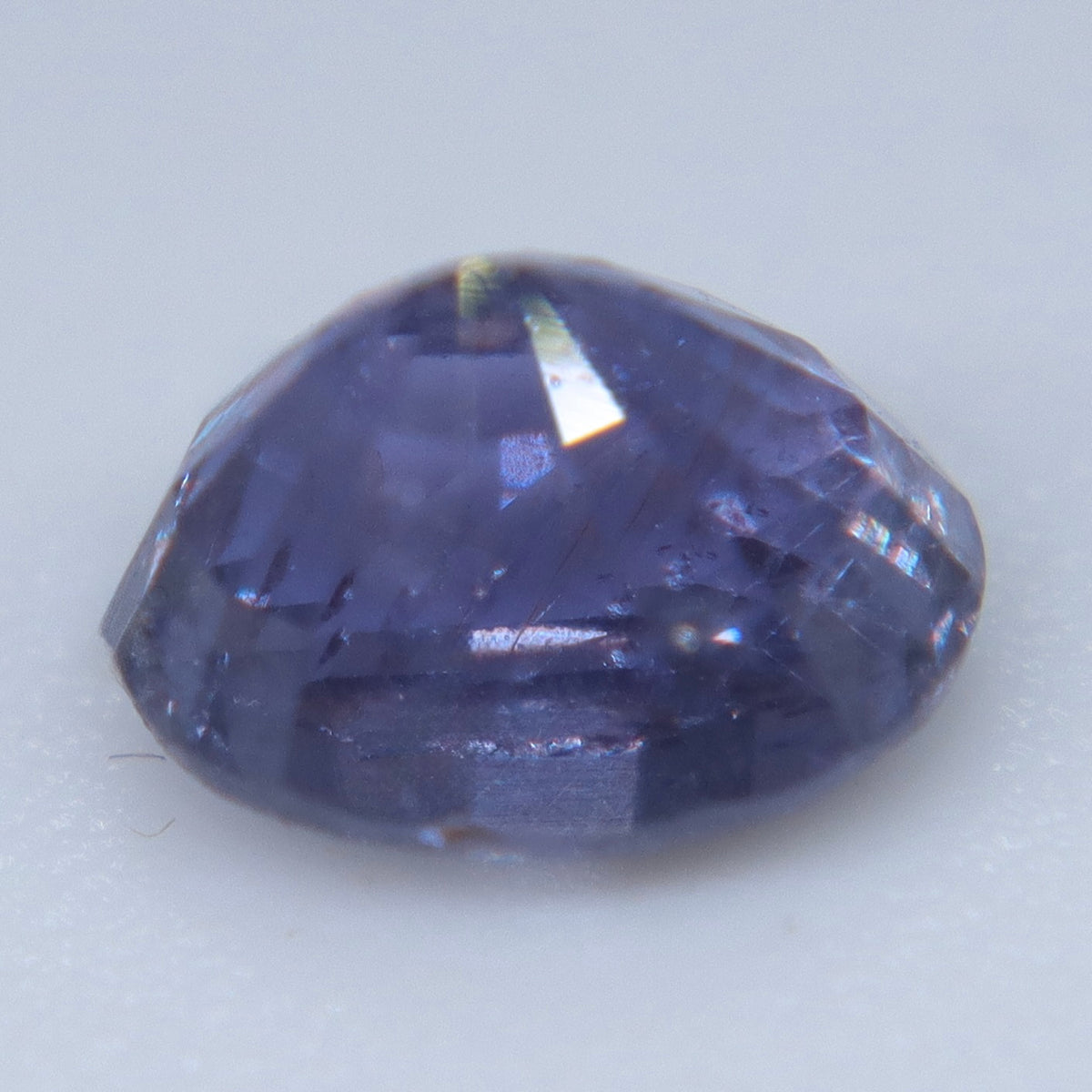 Side profile of a purple sapphire showing its crown, girdle, and deep pavilion