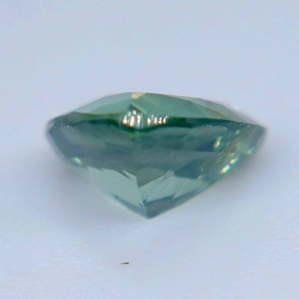 Side profile of a trillion cut green sapphire showing its crown and pointed pavilion