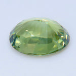 Side profile of an oval alexandrite showing its girdle and faceted pavilion.