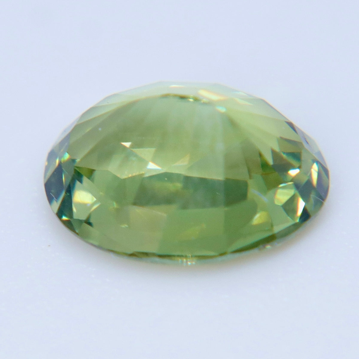 Side profile of an oval alexandrite showing its girdle and faceted pavilion.