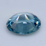 Side profile of an oval teal sapphire showing its crown, girdle, and pavilion