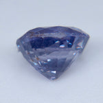 Underside view of an oval purple sapphire showing pavilion facets and inclusions