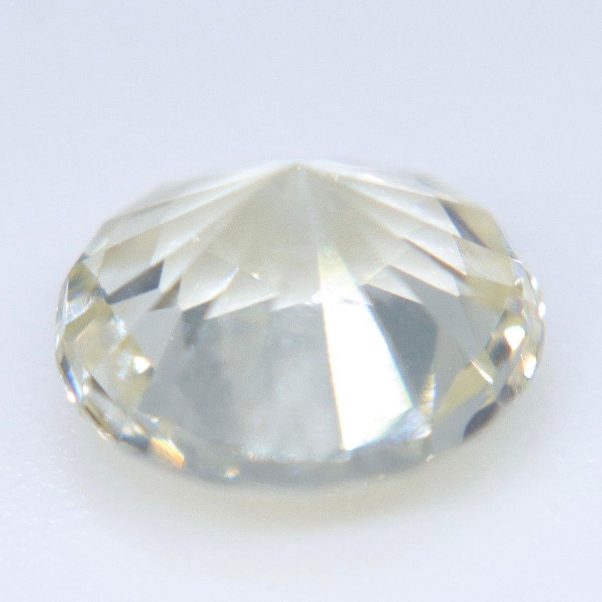 Unheated round white sapphire from Ceylon showing its faceted crown and warm undertone