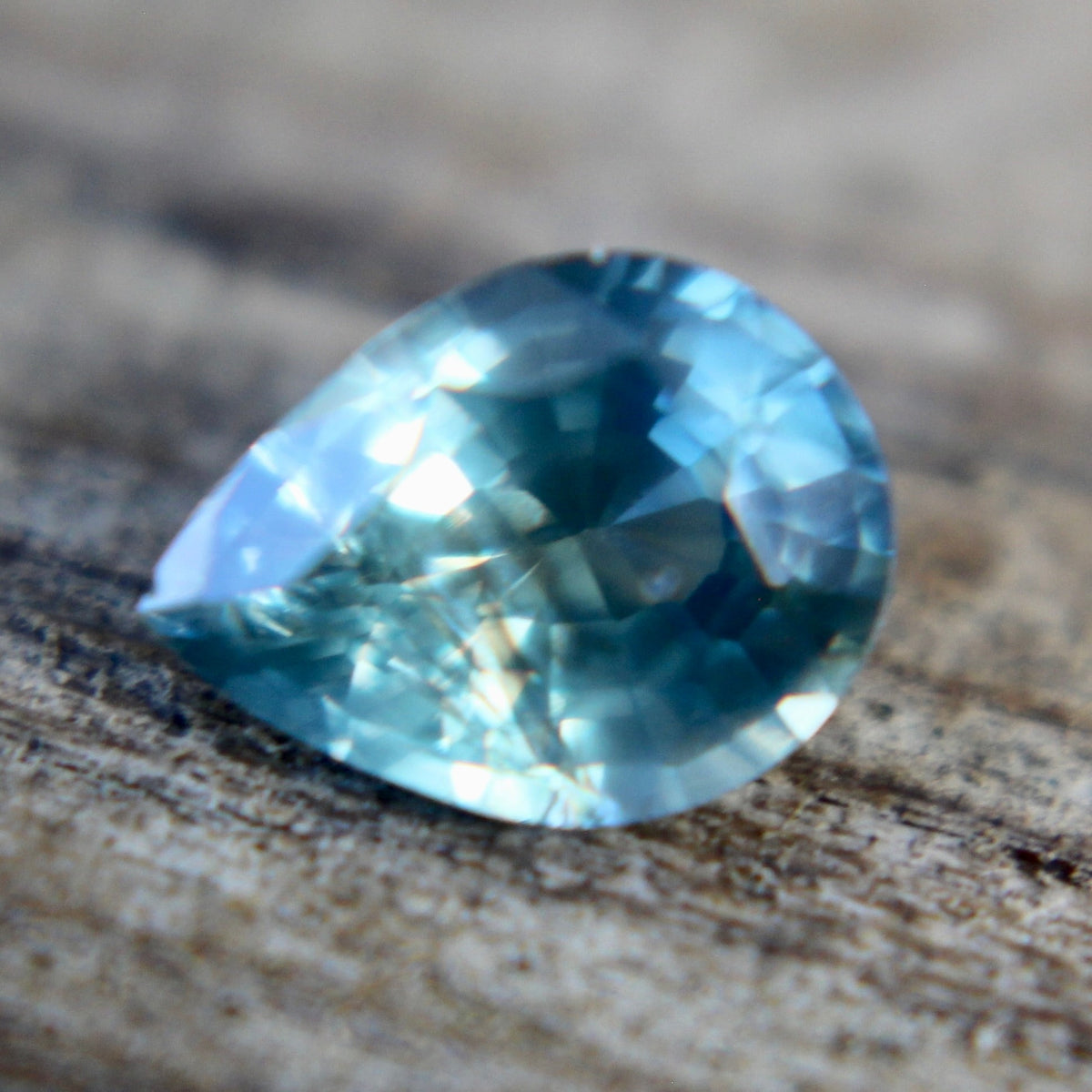 Side profile of a loose pear-cut sapphire showing its crown and pavilion