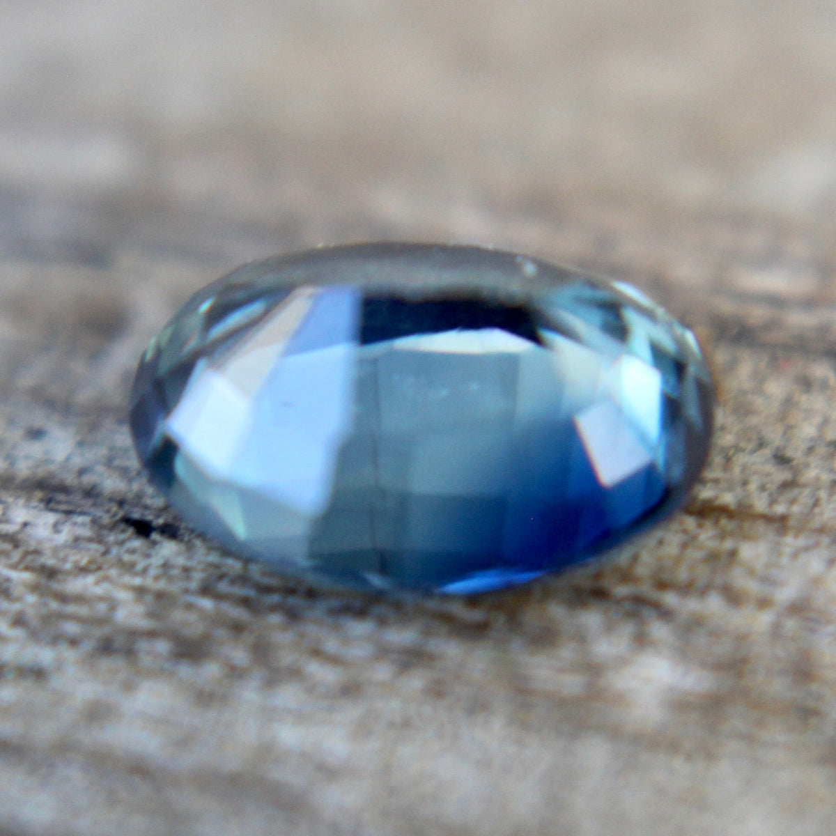 Angled view of a natural oval blue green sapphire from Madagascar