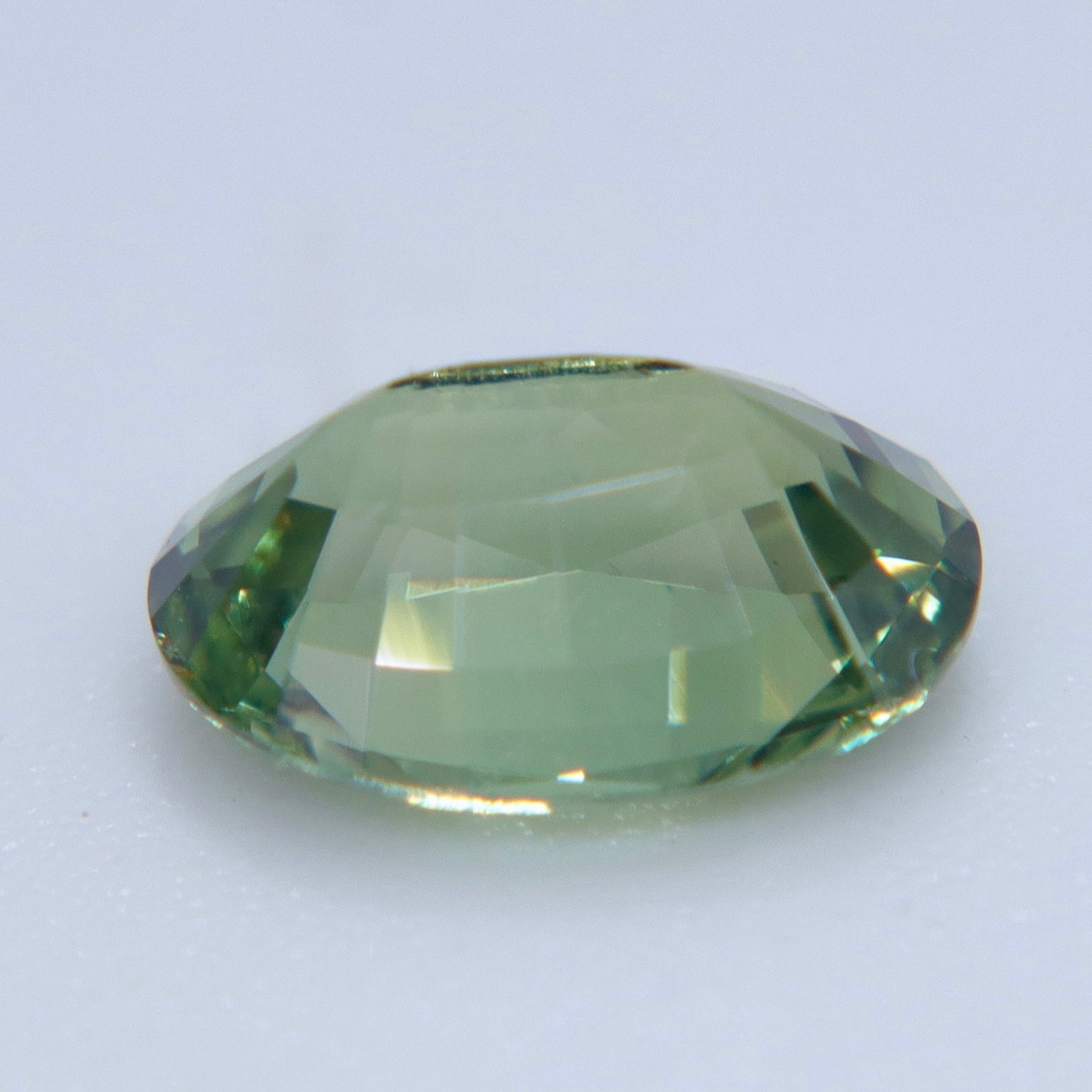 Untreated oval vanadium chrysoberyl showing golden color in warm light