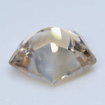 Pavilion view of the pale silver-champagne Ceylon sapphire showing its freeform cut and golden undertone