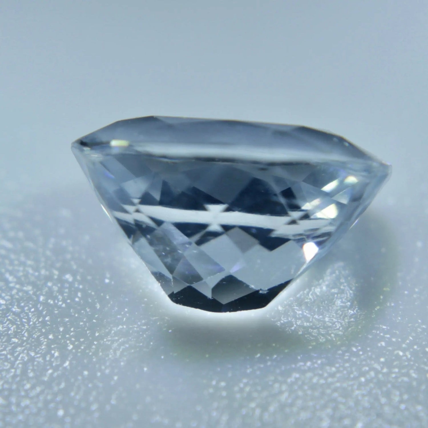 Cushion-cut Ceylon white sapphire showing its VVS clarity and faceted surface