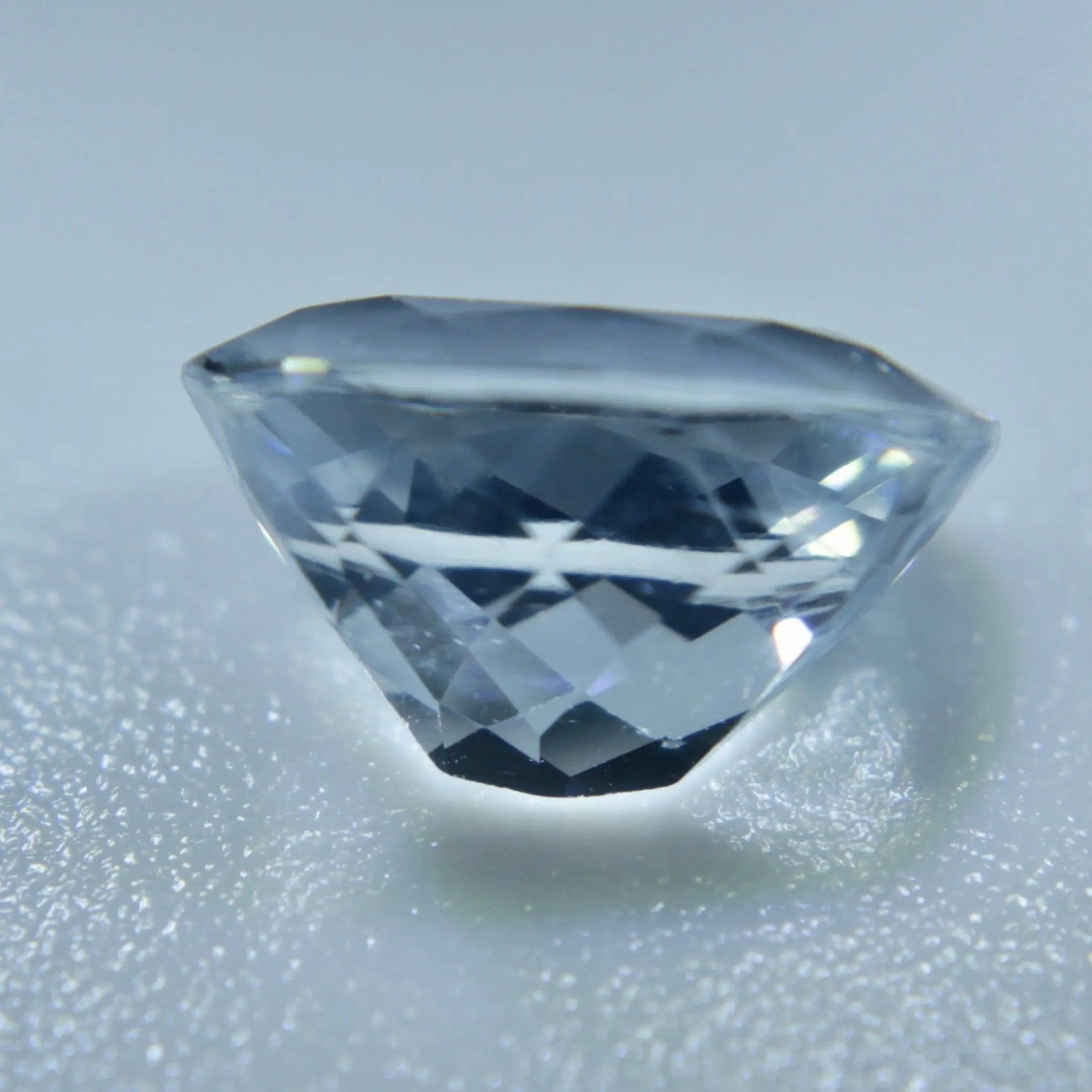 Cushion-cut Ceylon white sapphire showing its VVS clarity and faceted surface