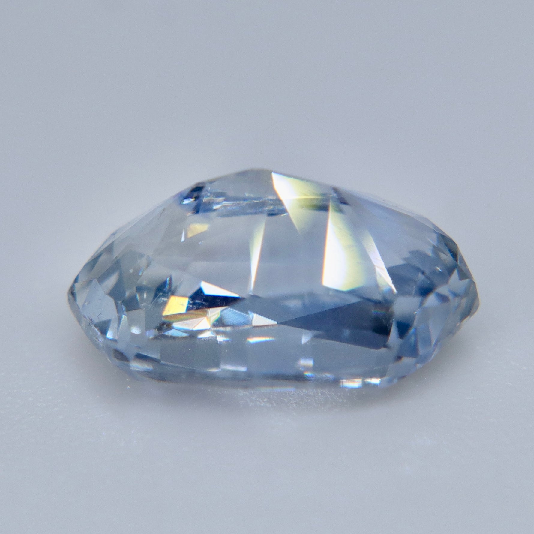 ngled view of an elongated cushion white sapphire with icy blue-gray reflections