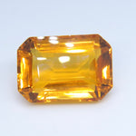 Golden emerald-cut citrine viewed at a slight angle, showing its step facets