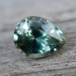 Angled view of a green sapphire showing its pear shape and crown facets
