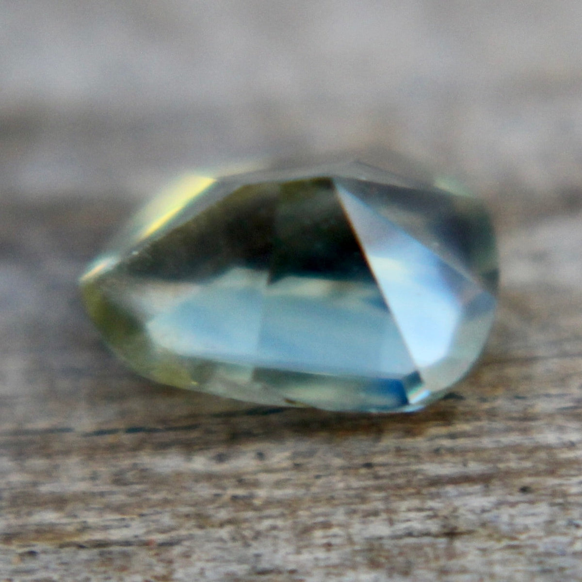 Angled view of a natural green trillion sapphire from Madagascar