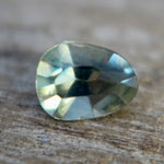 Close-up of the facets and inclusions in a green trillion sapphire