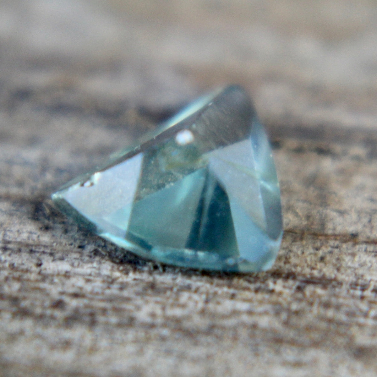 Angled view of a trillion cut green sapphire from Madagascar