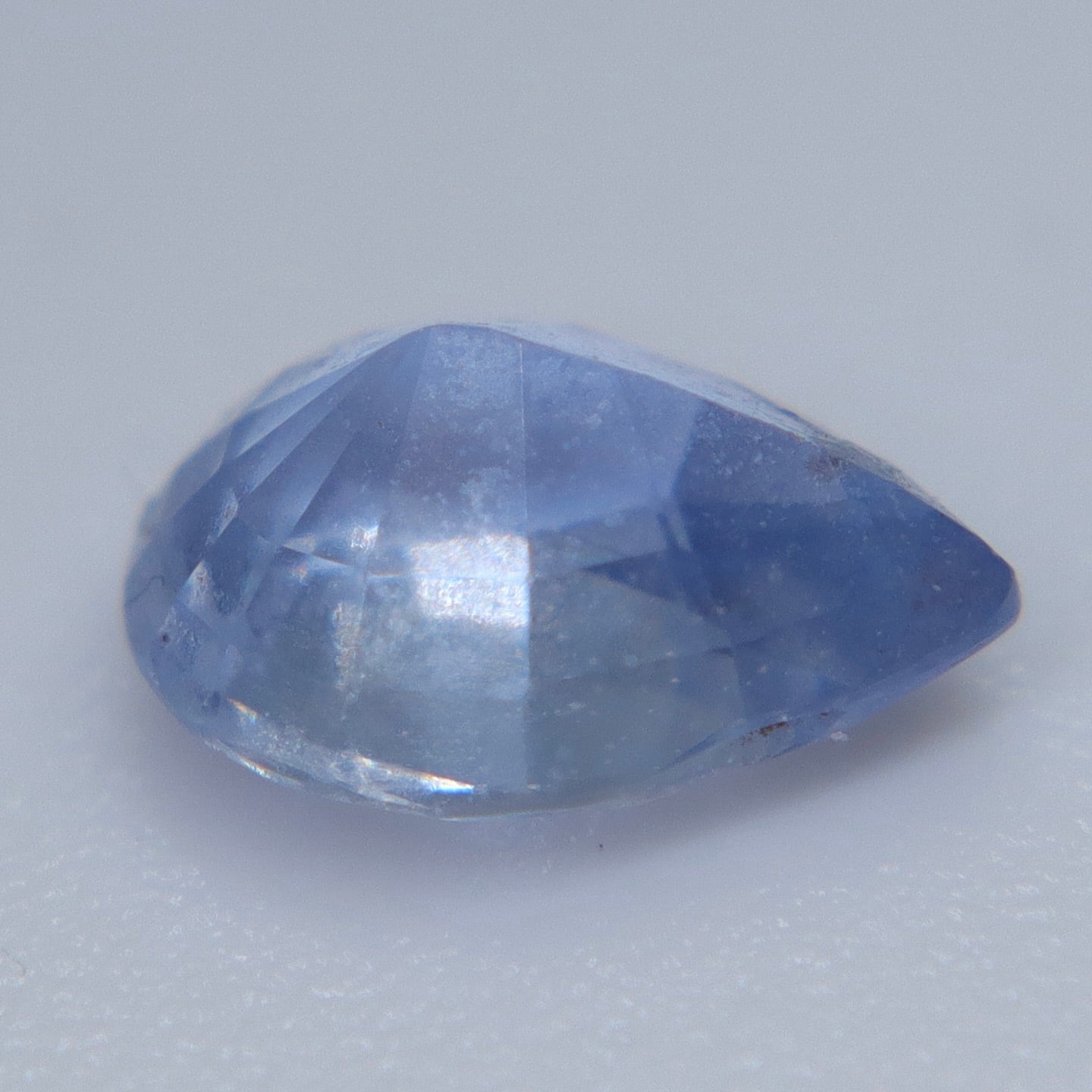 Heated natural blue Ceylon sapphire in a pear cut showing visible SI clarity characteristics