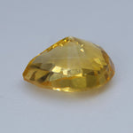 Side view of heated natural yellow sapphire showing its teardrop-cut profile