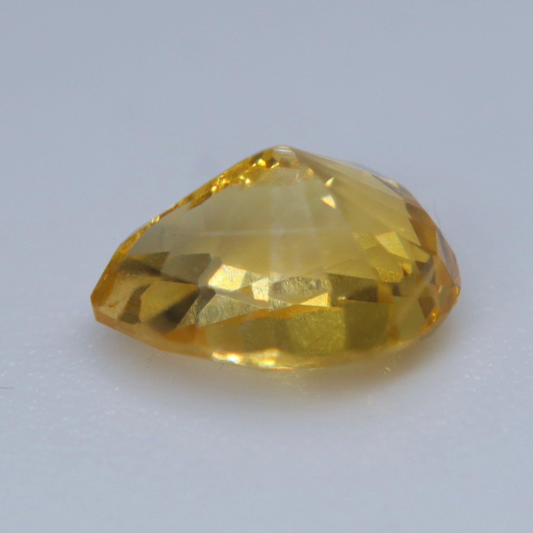 Side view of heated natural yellow sapphire showing its teardrop-cut profile