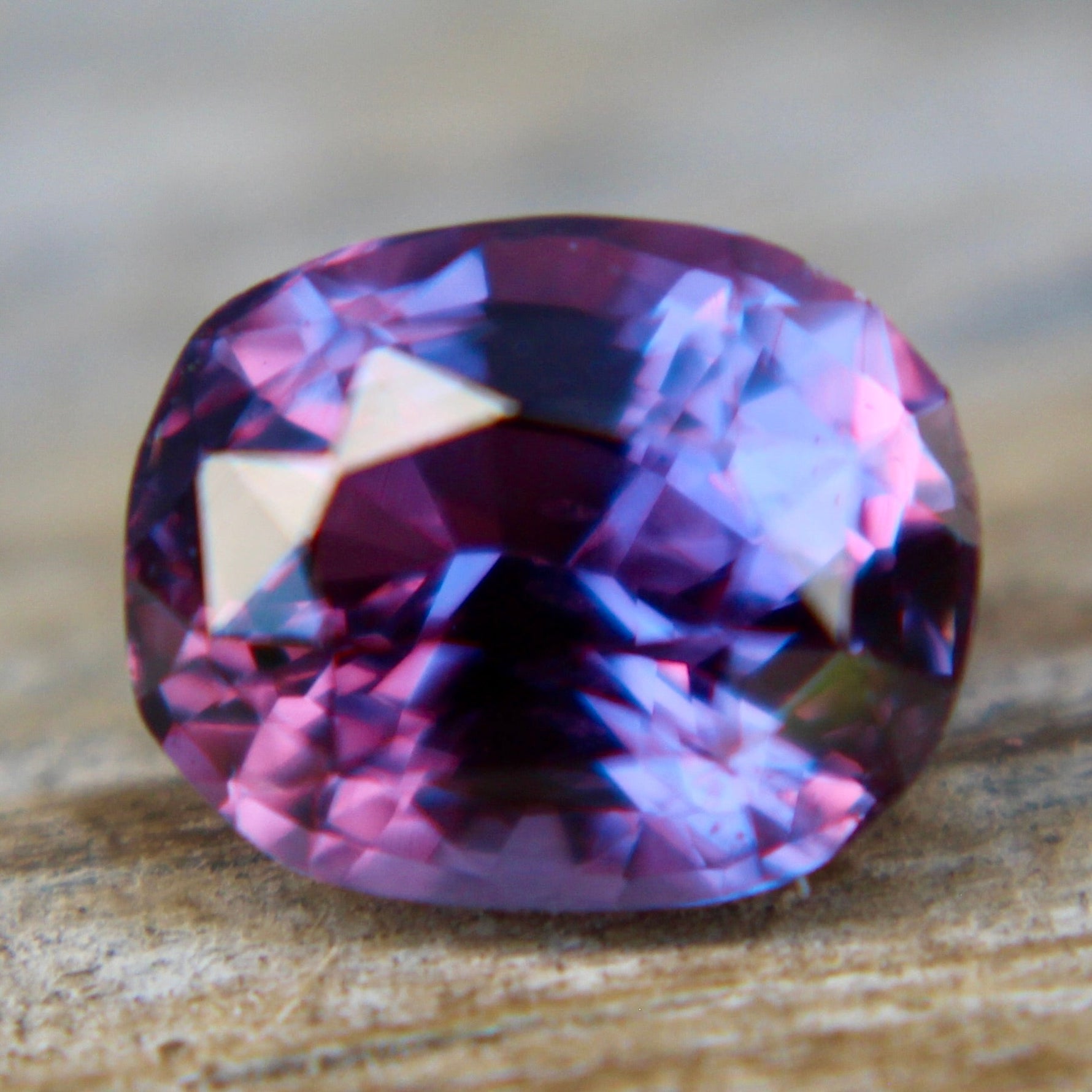 Loose 1.50 carat purple sapphire shown on hand for scale