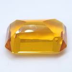 Tilted view of an emerald-cut citrine showing its golden color and pavilion facets