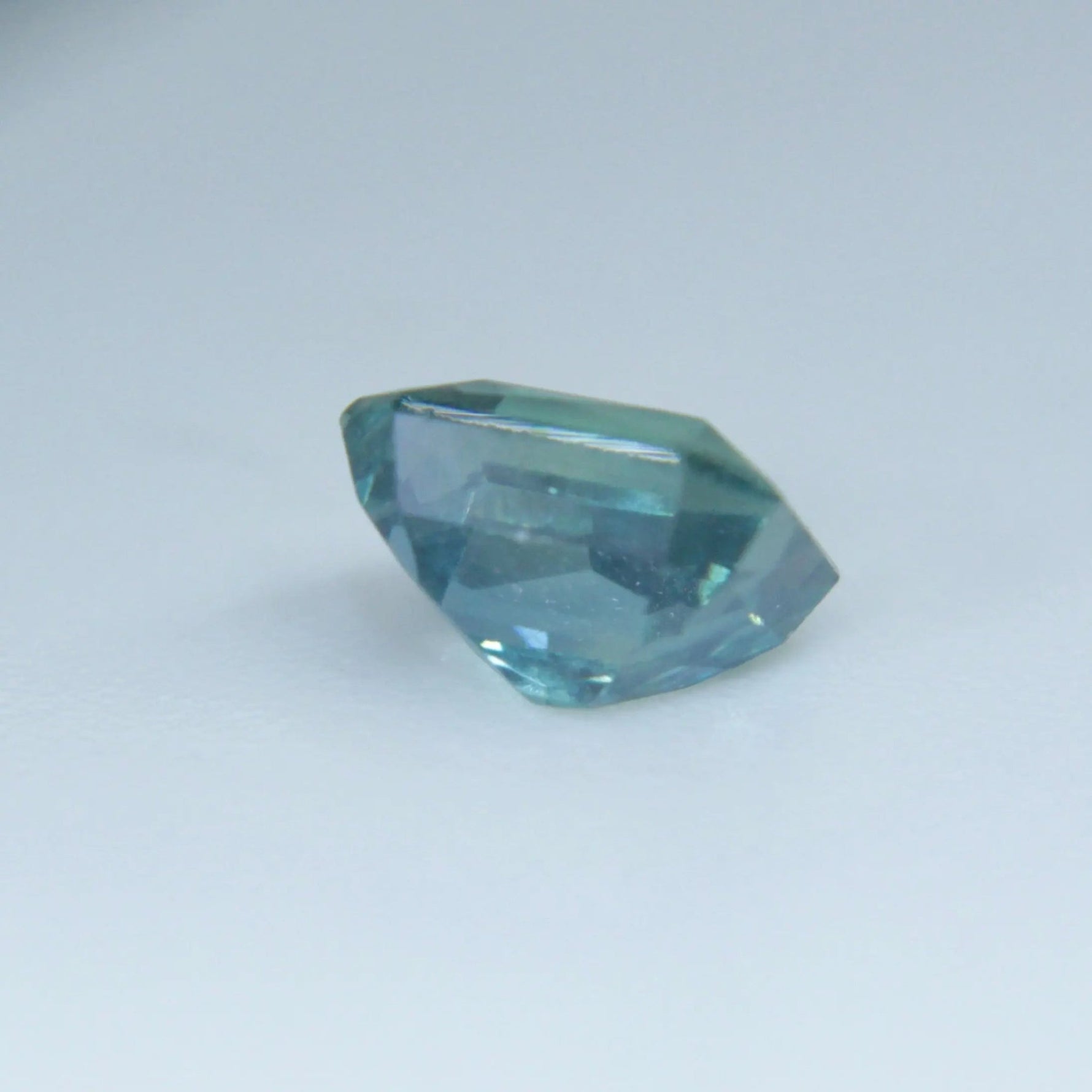 Ceylon green corundum with bright step-facet flashes