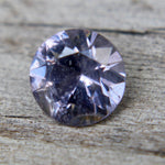Back view showing natural inclusions in a round purple spinel