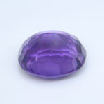 Angled view of a natural oval amethyst showing its facets
