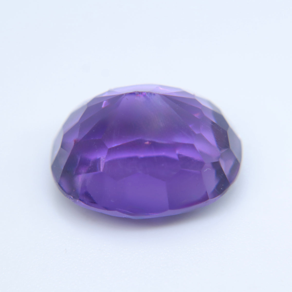 Angled view of a natural oval amethyst showing its facets