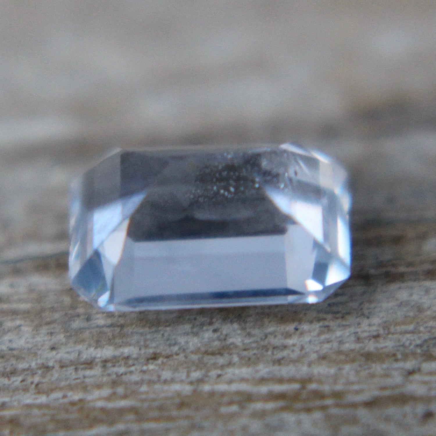 Emerald-cut pale blue sapphire with step facets and cool tone