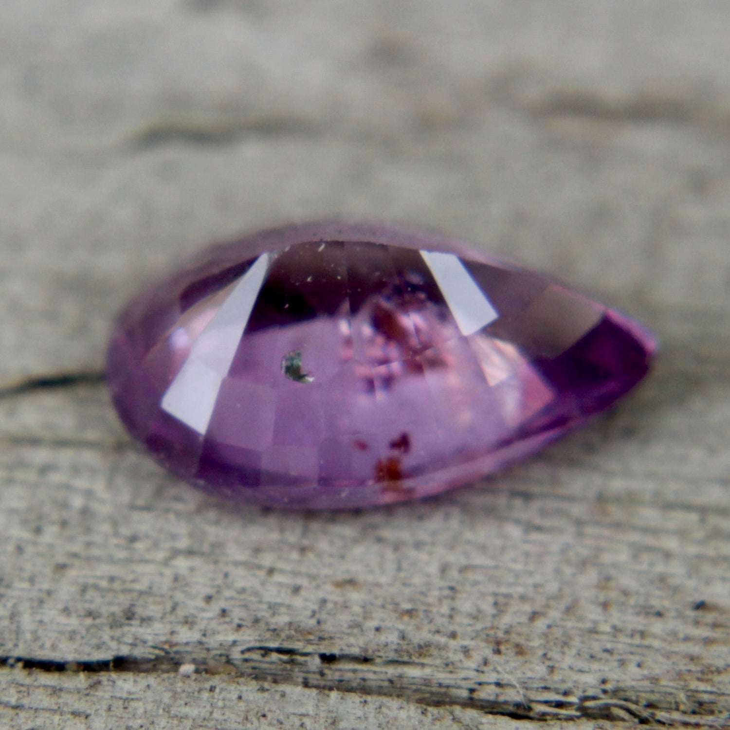 Pear cut purple sapphire 0.80 carat showing facets and luster in neutral light